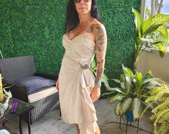 Vestido de cóctel BCBG MaxAzria color beige con fruncido y lazo en forma de corazón.