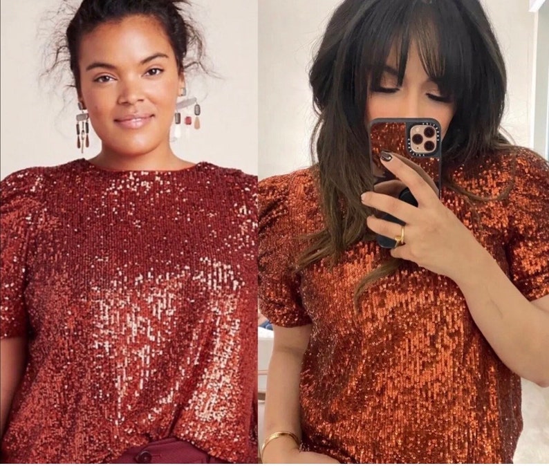 Pode incluir: Duas mulheres vestindo uma blusa de lantejoulas cor ferrugem com mangas curtas e um ombro levemente bufante. A blusa tem um decote redondo.