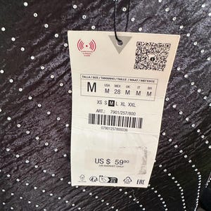 Puede incluir: Vestido negro con un patr&oacute;n de puntos brillantes. La etiqueta dice "M" para el tama&ntilde;o y "US $ 59.90" para el precio. La etiqueta tambi&eacute;n incluye el texto "US Market Only".