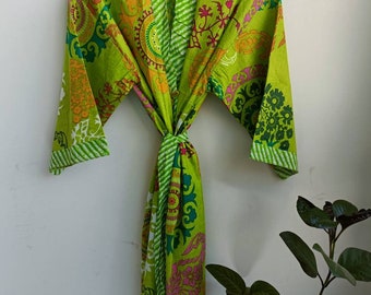 Könnte beinhalten: Eine grüne Baumwollrobe mit einem bunten Blumenmuster. Die Robe hat einen Bindegürtel und lange Ärmel.
