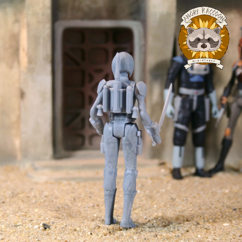 May include: A gray unpainted plastic miniature figurine of a warrior standing with their back to the viewer. The figure wears a helmet, a jetpack, and armor, and holds a thin sword in their right hand. The surface of the figure shows 3D print lines.