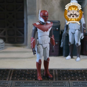 May include: A standing action figure of a soldier wearing white and red armour with a matching helmet. The figure features dark brown undersuit sleeves, red gauntlets, and red boots. A circular logo with a raccoon illustration and the text ANGRY RACCOON MINIATURES is visible in the upper right corner.