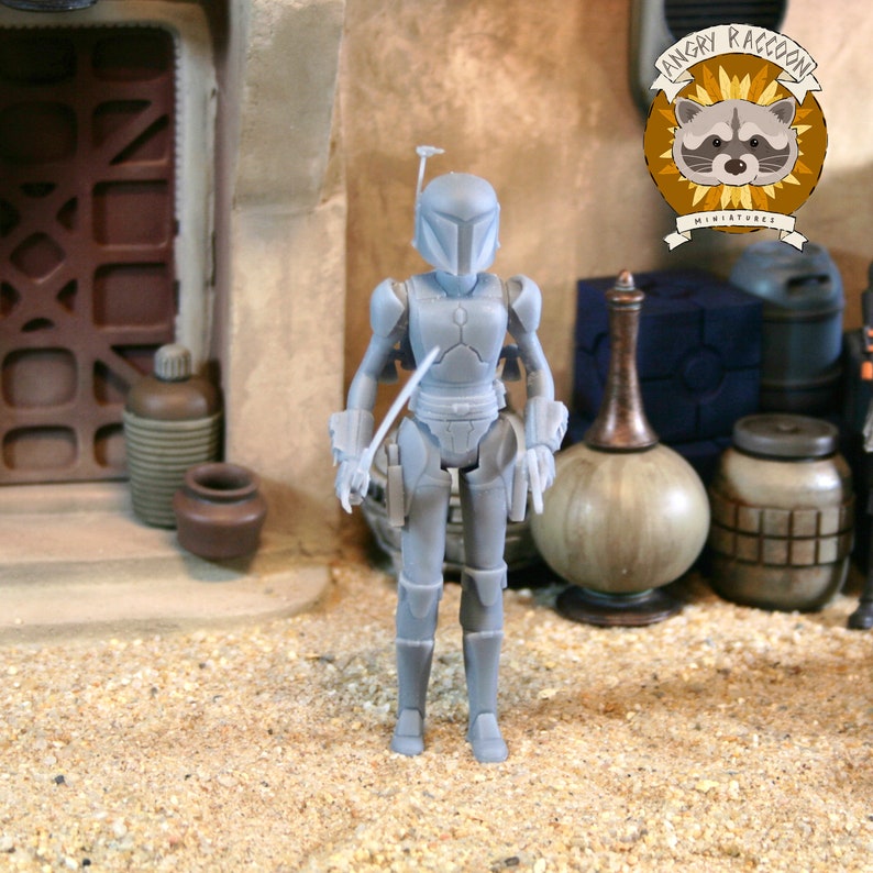 May include: A gray, unpainted resin action figure of a warrior wearing a helmet with a T-shaped visor and full body armor. The figure stands upright with articulated limbs and a jetpack on the back. A logo with a raccoon and the text ANGRY RACCOON MINIATURES is visible in the upper right corner.