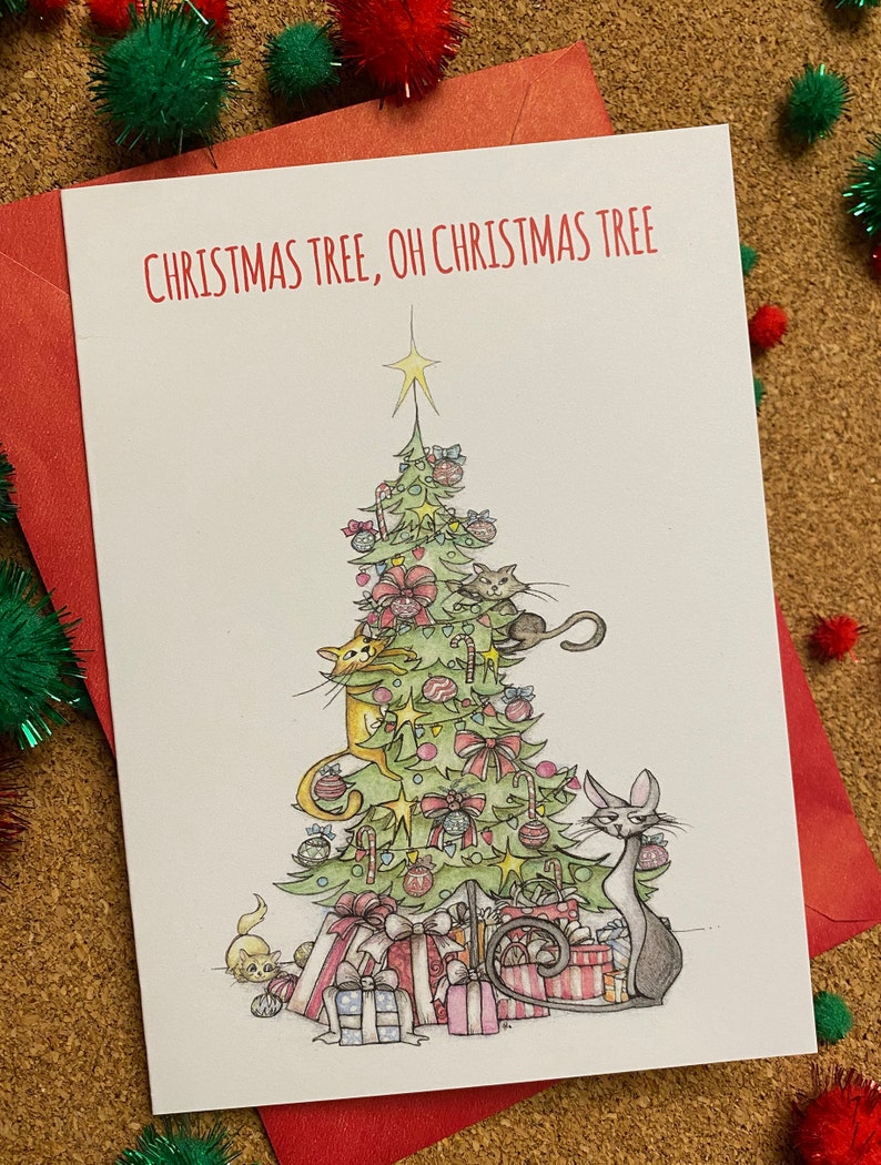 May include: A Christmas card featuring a green Christmas tree decorated with ornaments, candy canes, and bows.  Cats are climbing the tree and playing with the decorations. The card reads "Christmas Tree, Oh Christmas Tree".