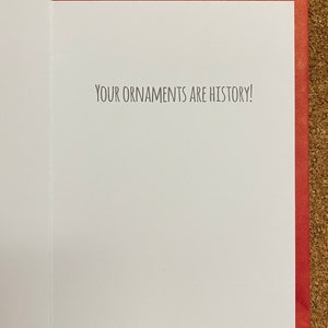 May include: A red card with a white interior. The inside of the card has the text "YOUR ORNAMENTS ARE HISTORY!" printed in black.