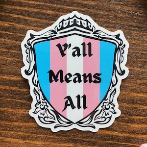 Pegatina del escudo del orgullo trans "Y'all Means All" de la Feria Ren con bandera transgénero