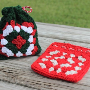 May include: Two crocheted drawstring bags, one green with red and white squares, and one red with white squares.
