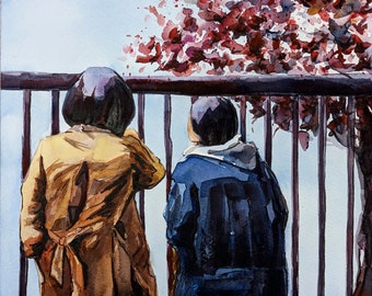 May include: Two people stand side-by-side, looking out at a view. The person on the left is wearing a brown jacket and the person on the right is wearing a blue jacket. They are standing in front of a railing with a red and pink tree in the background.