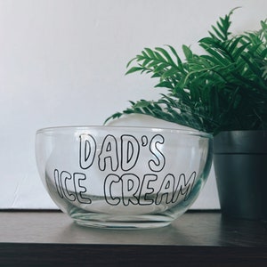 K&ouml;nnte beinhalten: Eine durchsichtige Glassch&uuml;ssel mit dem Aufdruck "Dad's Ice Cream" in Schwarz auf der Seite.