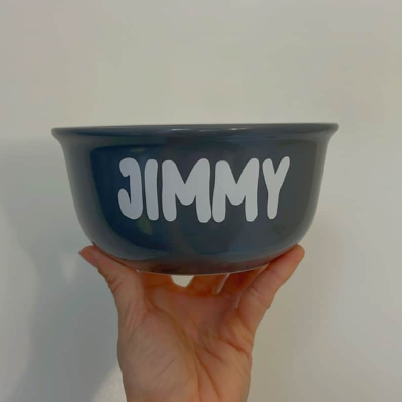 K&ouml;nnte beinhalten: Eine dunkelgraue Keramiksch&uuml;ssel mit dem Namen "JIMMY" in wei&szlig; auf der Vorderseite.