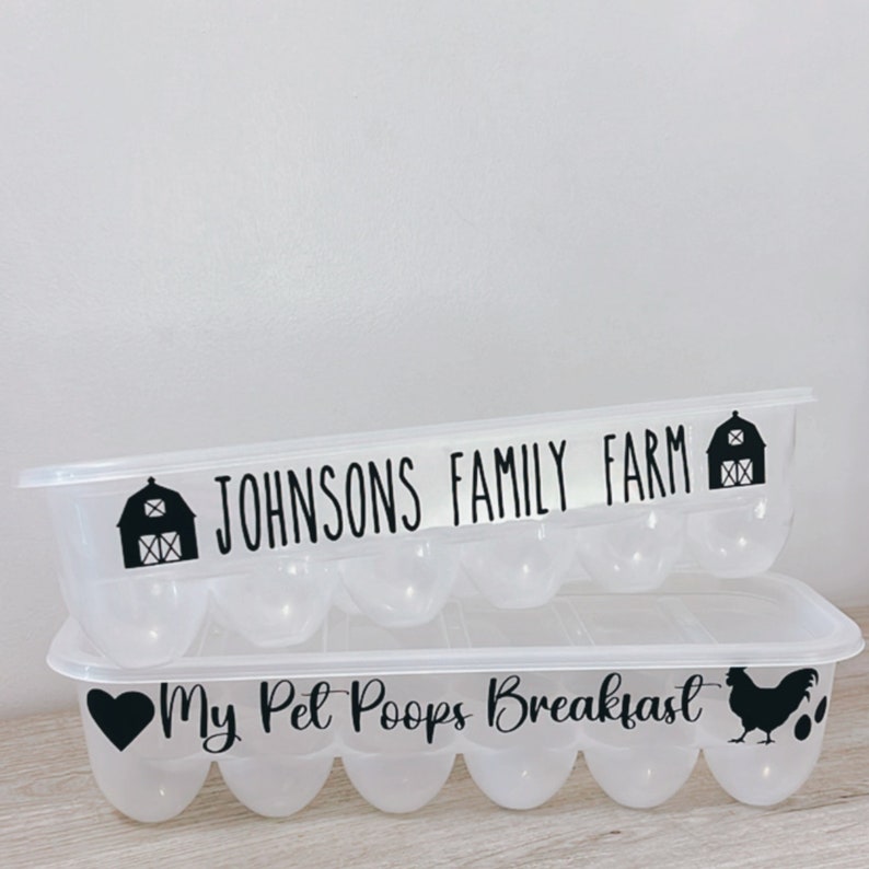 May include: Two clear plastic egg containers, one stacked on top of the other. The top container reads "JOHNSONS FAMILY FARM" with a barn graphic. The bottom container reads "My Pet Poops Breakfast" with a heart, chicken, and egg graphics.