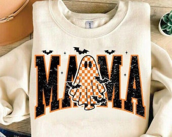 May include: Cream-colored sweatshirt with the word "MAMA" in black and orange block letters. A checkered ghost graphic is in the center, with bats and stars. A Halloween-themed design.