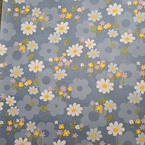 Wipeable daisy fabric in blue background with yellow and lilac accents