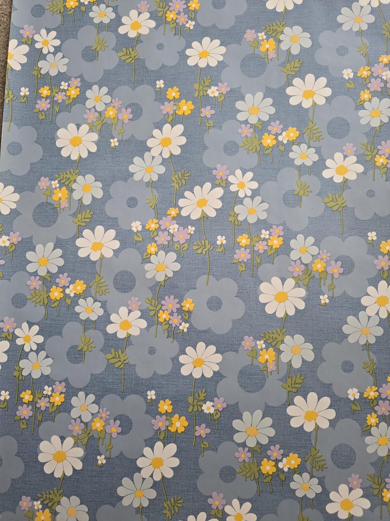 Wipeable daisy fabric in blue background with yellow and lilac accents