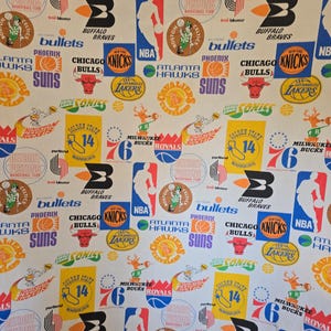 May include: White fabric with a repeating pattern of vintage NBA team logos. The design includes logos for teams such as the Lakers, Knicks, Bulls, and Celtics, in various colours.