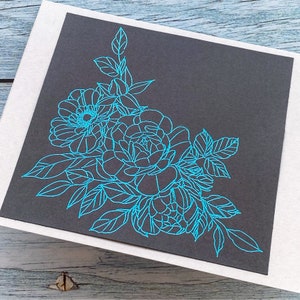 May include: A black card with a blue floral design. The design features a cluster of roses and leaves in the corner of the card.