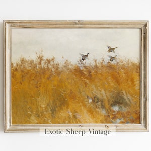 May include: A framed vintage painting of a field of tall, golden grass with three ducks flying over it. The painting has a light brown frame.