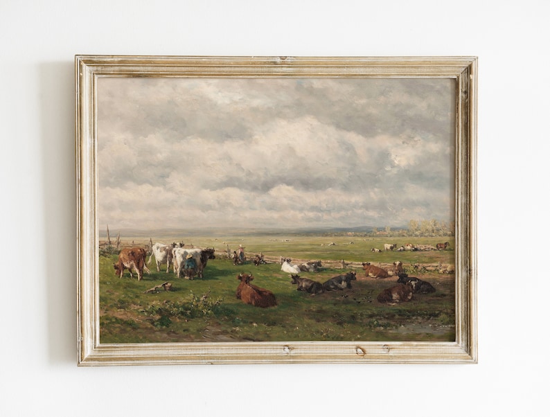 May include: A framed oil painting depicting a pastoral scene with a herd of cows grazing in a green field under a cloudy sky.
