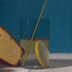 Pode incluir: Um copo de limonada com uma fatia de lim&atilde;o e um agitador de madeira, ao lado de um peda&ccedil;o de p&atilde;o sobre uma superf&iacute;cie branca.