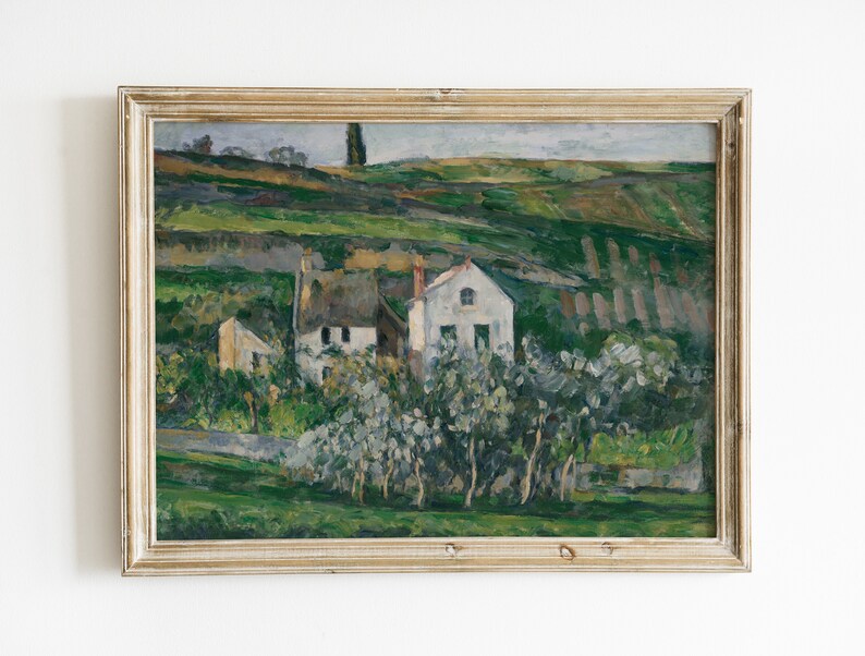 May include: A framed painting depicting a landscape with a white house and green trees. The house has a brown roof and a white chimney. The trees are in the foreground of the painting, and the house is in the background. The painting is set against a backdrop of rolling hills.