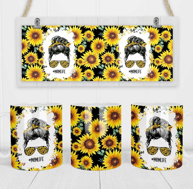 May include: Three white ceramic mugs with a black background and a pattern of yellow sunflowers. The mugs feature a black and white illustration of a woman with a bun in her hair and sunglasses. The text "#MOMLIFE" is printed on each mug.