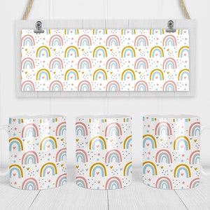 May include: Three white ceramic mugs with a rainbow pattern. The pattern features rainbows in shades of pink, blue, and yellow with white, pink, and yellow stars and hearts.