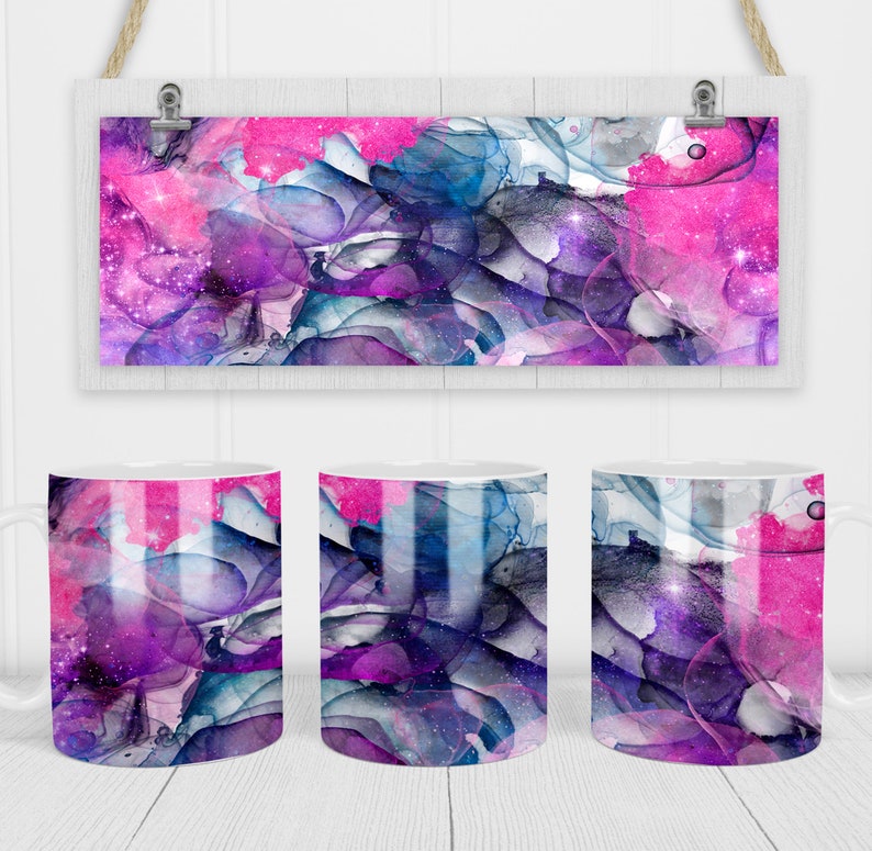 May include: White ceramic mugs with a vibrant abstract design featuring shades of pink, purple, blue, and gray. The design resembles watercolor or ink art with a starry effect. A matching rectangular art print hangs above the mugs.