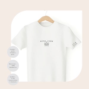 May include: White t-shirt with the text "wine crew" and a graphic of wine glasses. The shirt also has the word "LISA" on the right sleeve.