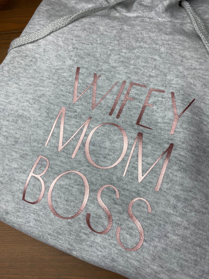May include: Gray hooded sweatshirt with the text "WIFEY MOM BOSS" in rose gold foil lettering.