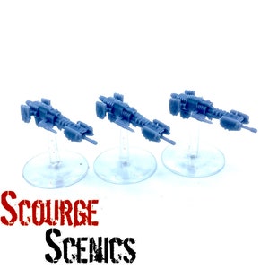 May include: Three grey miniature spaceship models on clear stands. The spaceships have detailed designs with multiple sections and protruding elements. The image includes the text "Scourge Scenics" in red and black.