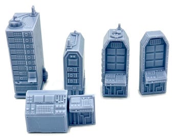 May include: A collection of light blue miniature sci-fi structures, including tall rectangular buildings with multiple levels and control panels, and smaller control consoles. The pieces have detailed textures and are designed for tabletop gaming or model building.