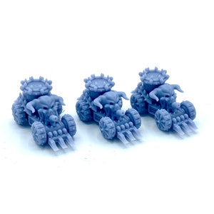 Peut inclure: Trois petits chars gris avec un design de crâne cornu. Chaque char a une tourelle circulaire, des roues à pointes et une rangée de petits crânes. Les chars sont sur fond blanc.