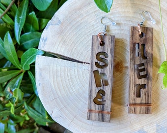 she/her pronoun earrings, copper on hardwood