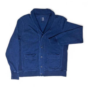 Könnte beinhalten: Marineblauer Cardigan mit Schalkragen, zwei Vordertaschen und Knopfverschlüssen. Der Pullover in Größe Large ist aus einem weichen, bequemen Material gefertigt. Die Ärmel haben gerippte Bündchen.