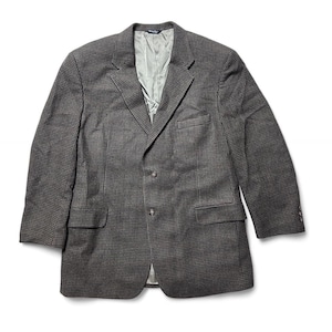 Può includere: Blazer a due bottoni con motivo a pied-de-poule, nei toni del grigio e del marrone. La giacca ha due tasche anteriori e un revers a lancia. La fodera interna è di colore verde chiaro.