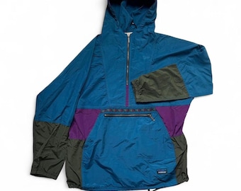Peut inclure: Un coupe-vent à capuche de type pullover bleu sarcelle, violet et gris foncé, doté d'une fermeture éclair à mi-hauteur, d'une poche horizontale zippée sur le devant, de manches longues à poignets élastiques et d'une étiquette L.L.Bean.