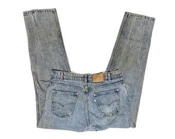Puede incluir: Un par de pantalones vaqueros de mezclilla azul claro con un aspecto descolorido. Los vaqueros tienen un estilo clásico de cinco bolsillos y un parche de cuero marrón en la parte posterior.