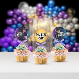 May include: Three cupcakes with purple, gold, and blue frosting. Each cupcake has a round topper with a cartoon character and text. The toppers say "Purple Squad", "Find'N Out", and "Blue Squad".