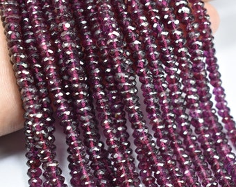 May include: A strand of deep purple faceted gemstone beads. The beads are small and round, and they have a shiny, polished finish.