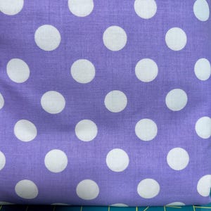 May include: Purple fabric with white polka dots.