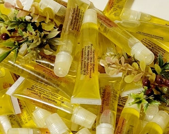 Könnte beinhalten: Nahaufnahme eines Stapels transparenter Plastikröhrchen, die mit einer gelben Flüssigkeit gefüllt sind. Die Röhrchen haben einen Roll-on-Applikator und sind mit "Rosemary Hot Oil" beschriftet. Die Zutaten sind wie folgt aufgeführt: Bio-Rosmarin, Olivenöl, Kokosnussöl, Hanföl, Mandelöl, Avocadoöl, Rizinusöl und ätherisches Rosmarinöl.