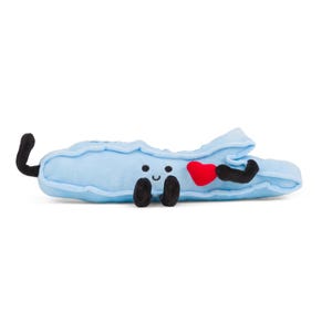 May include: A light blue plush toy shaped like a shoe, with black arms and legs, and a black tail. The toy has a smiling face and is holding a red heart. The toy is on a white background.