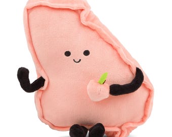 May include: A plush peach-shaped toy with a smiling face and black arms and legs. The toy is holding a small green leaf in its right hand.