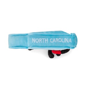 K&ouml;nnte beinhalten: Ein hellblaues Pl&uuml;schtier mit den Worten "NORTH CAROLINA" in Wei&szlig; gestickt. Das Spielzeug hat schwarze und rote Akzente. Das Spielzeug ist ein Souvenir oder ein Sammlerst&uuml;ck.