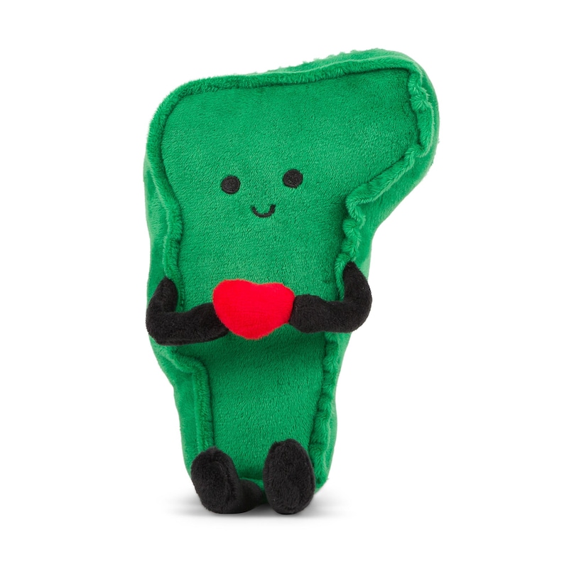 May include: Green plush toy shaped like a broccoli floret with a smiling face and holding a red heart.