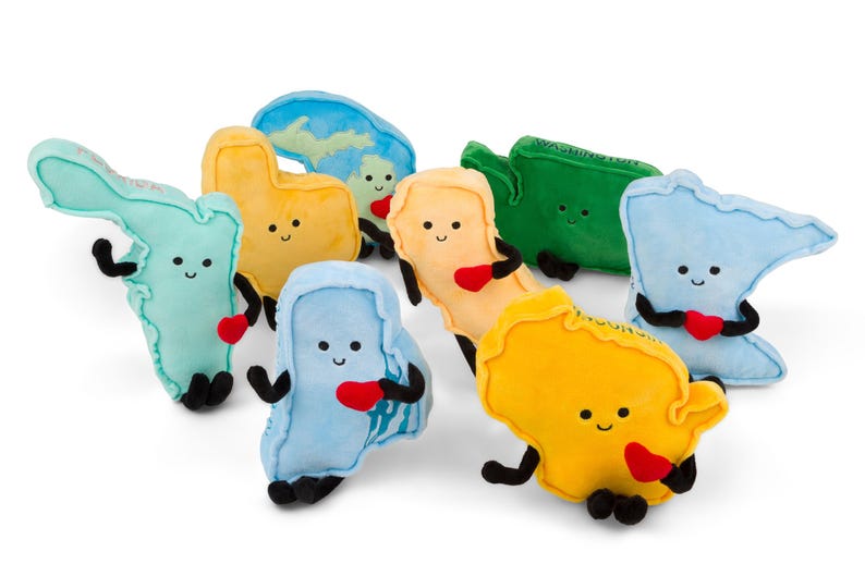Puede incluir: Colecci&oacute;n de peluches con forma de varios estados de EE. UU. Cada peluche es de un color diferente, con caras sonrientes, brazos y piernas negros y un coraz&oacute;n rojo. Algunos tienen nombres de estados bordados.