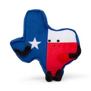 May include: A plush toy shaped like the state of Texas with the Texas flag colors and a smiling face. The toy has black arms and legs.