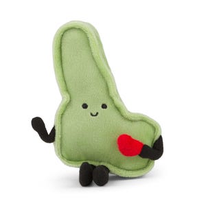 Może przedstawiać: Pluszowa, jasnozielona zabawka w kształcie fasoli z uśmiechniętą twarzą. Ma czarne ramiona i nogi i trzyma małe czerwone serce. Zabawka jest miękka i przytulna.