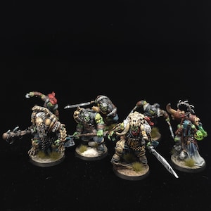 Puede incluir: Un grupo de seis miniaturas de orcos de fantasía pintadas a mano sobre bases circulares. Las figuras presentan piel verde, armaduras detalladas y diversas armas, incluyendo mazas, espadas y hachas. Algunas llevan cráneos de animales y pieles.
