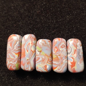 May include: Five rectangular ceramic tiles with a marbled pattern in shades of pink, white, and light blue.